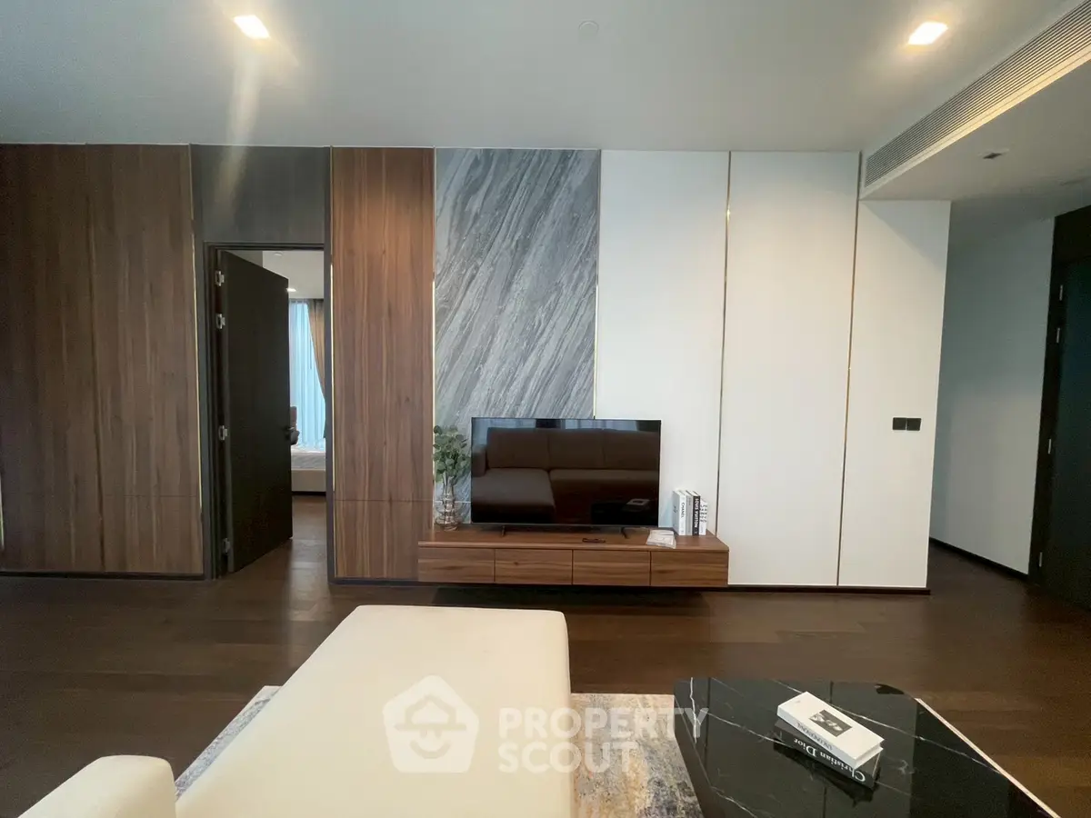 Modern living room with sleek design, featuring a wall-mounted TV and stylish furniture.