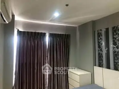 Cozy bedroom with modern decor and ample natural light from large windows.