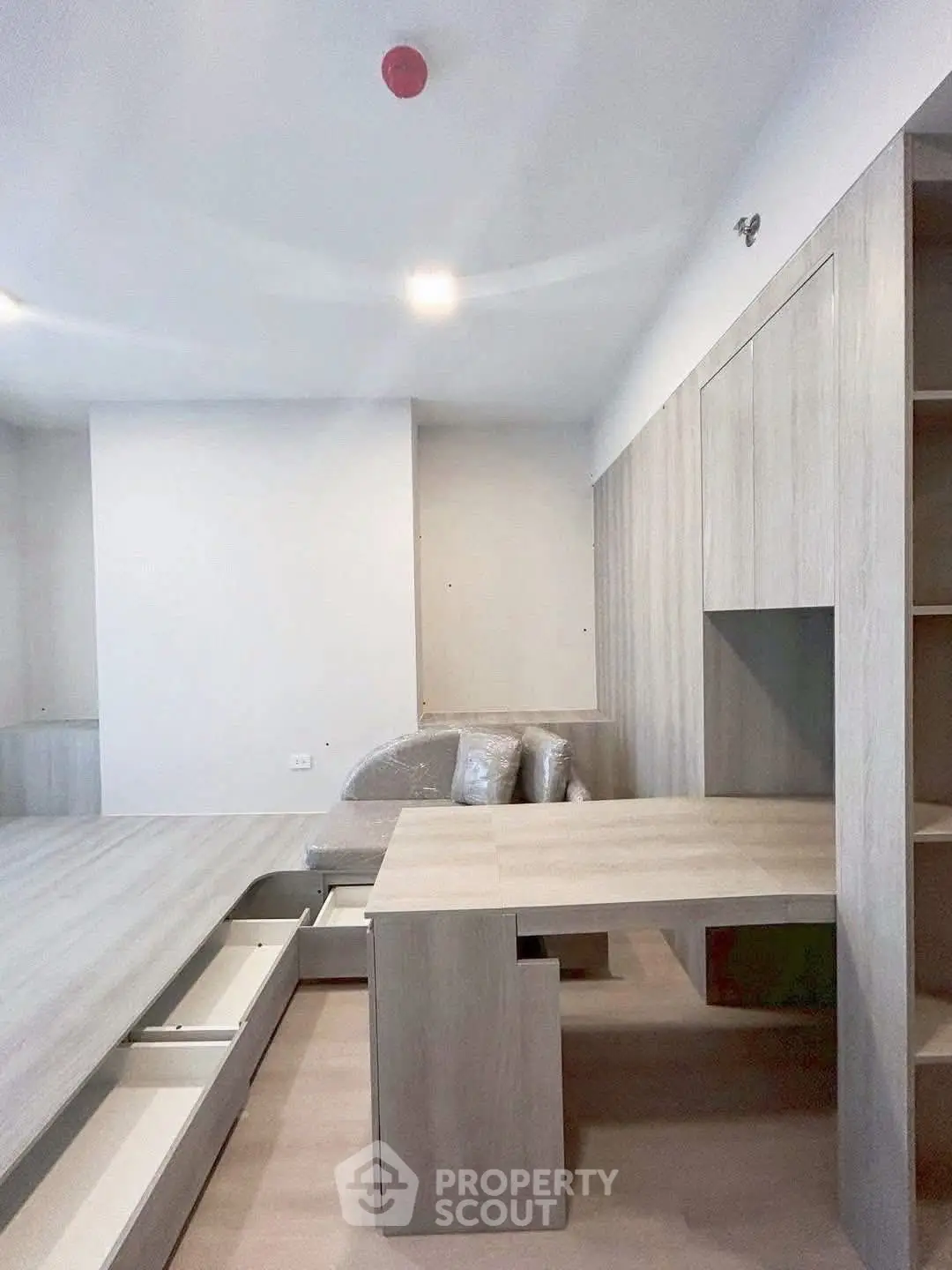 Modern minimalist living room with built-in storage and sleek wooden furniture.