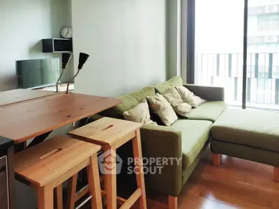 Modern living room with green sofa and wooden furniture, featuring a cozy and inviting atmosphere.