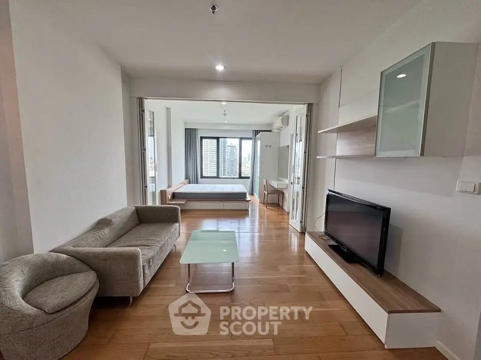 Modern open-plan living room with wooden flooring and city view