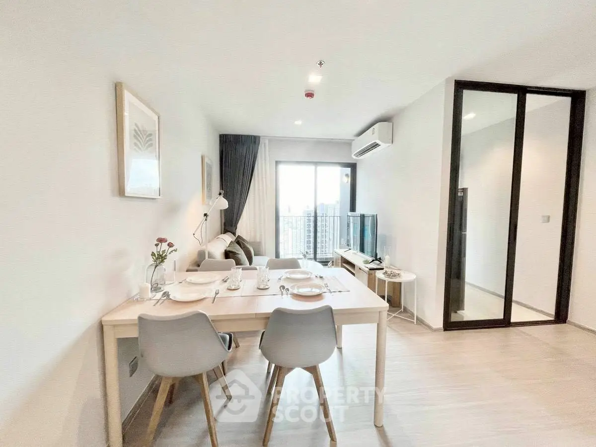 Modern living room with dining area and city view in a stylish apartment.