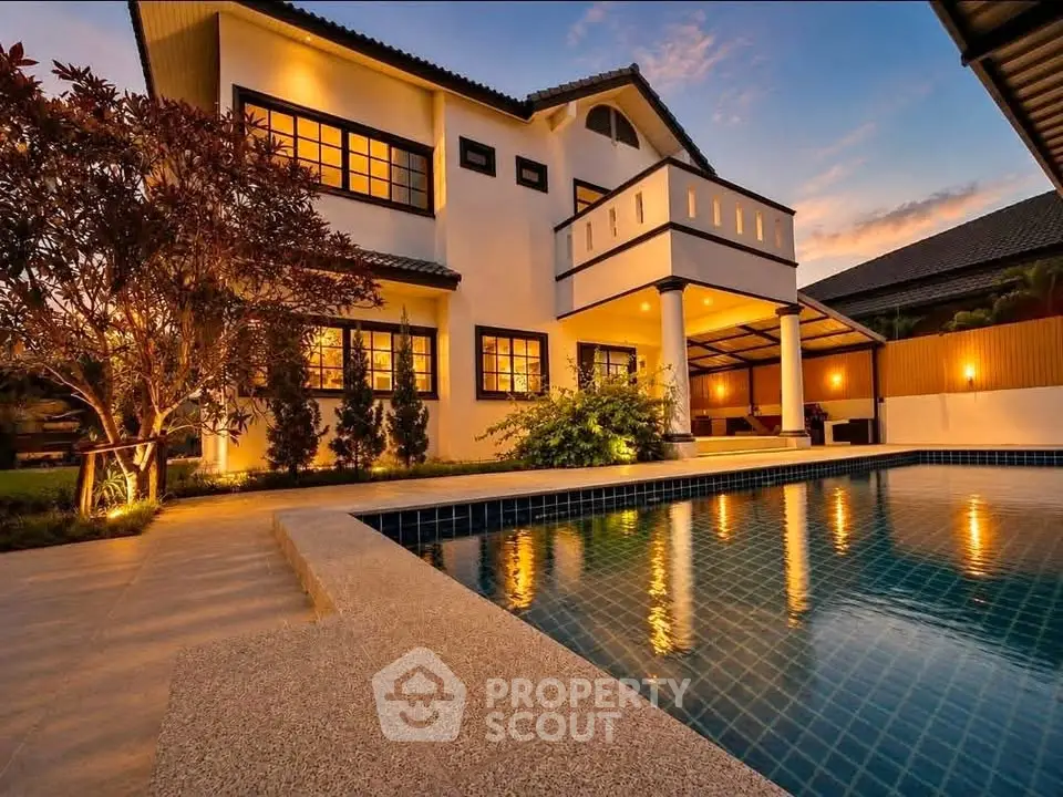 Luxurious villa with stunning pool and elegant exterior lighting at sunset.
