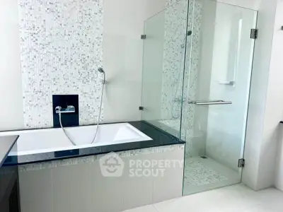Luxurious modern bathroom with glass shower and elegant bathtub