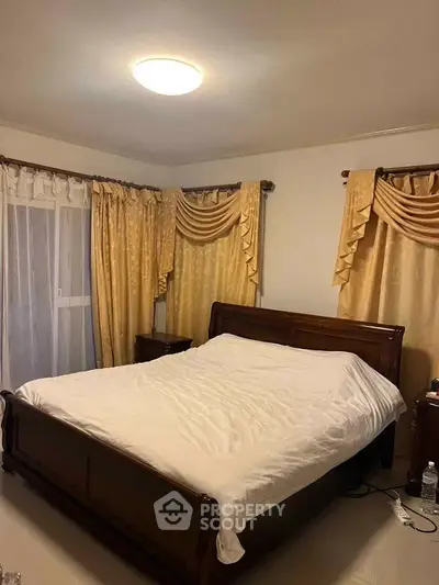 Cozy bedroom with elegant wooden bed and luxurious curtains