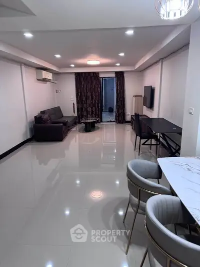 Spacious modern living room with sleek furniture and elegant lighting, perfect for comfortable living.