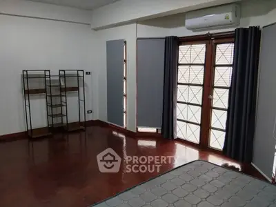 Spacious living room with wooden flooring and modern shelving units