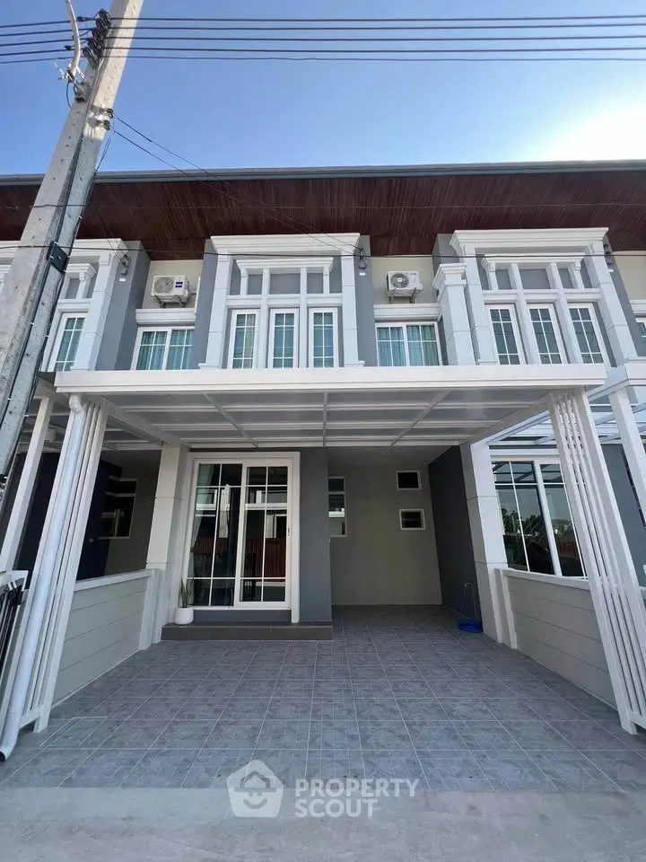 Modern townhouse exterior with large windows and covered entrance, perfect for urban living.