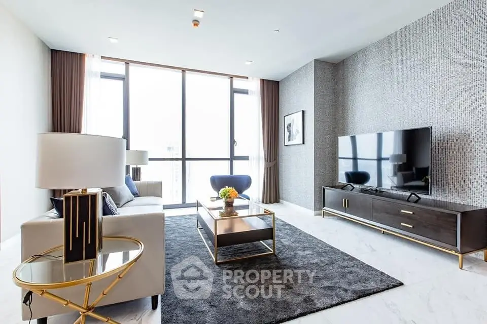 Chic modern living room with plush seating, sleek entertainment unit, and floor-to-ceiling windows offering ample natural light.