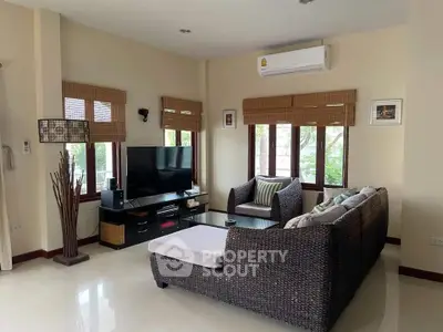 Cozy living room with wicker furniture and large windows for natural light.