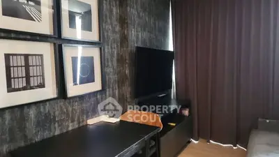 Modern living room with stylish decor and wall art, featuring a sleek TV setup and cozy ambiance.