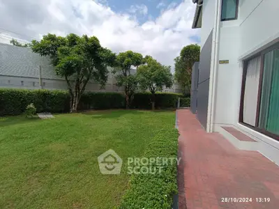 Spacious garden view with lush greenery and modern house exterior