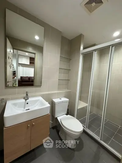 Modern bathroom with sleek design, featuring a spacious shower and elegant fixtures.
