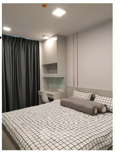 Modern bedroom with stylish decor and cozy ambiance, featuring a comfortable bed and study area.