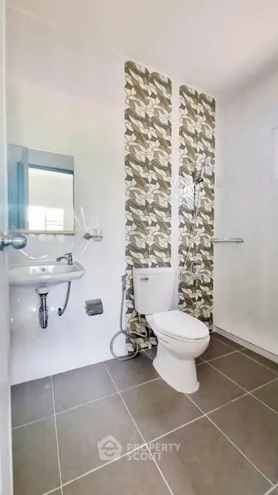 Modern bathroom with stylish tile accent wall and sleek fixtures.