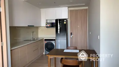 Modern kitchen with sleek cabinetry and integrated appliances, complemented by a cozy dining area, perfect for urban living.