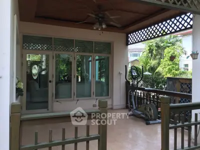 Charming balcony with exercise equipment and lush garden view, perfect for relaxation and fitness.