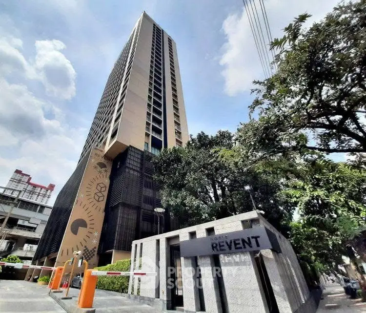Modern high-rise building with unique architectural design and lush greenery