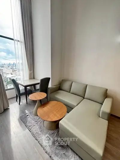 Modern living room with city view, featuring sleek furniture and floor-to-ceiling windows.