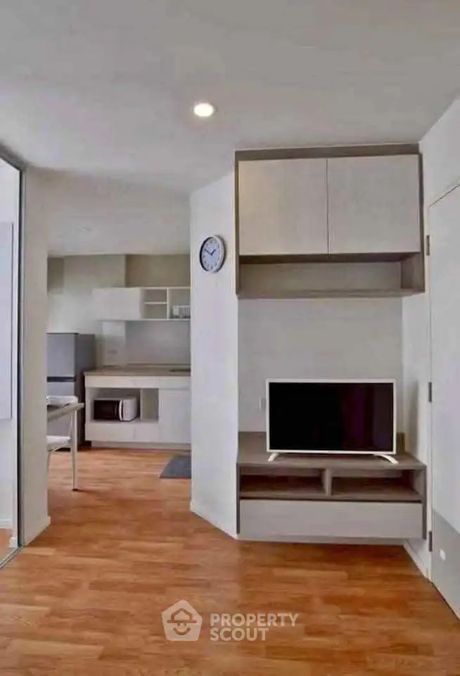 Modern living room with sleek wooden flooring and built-in entertainment unit