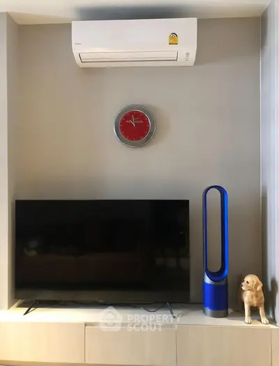 Modern living room with air conditioner, TV, and stylish decor