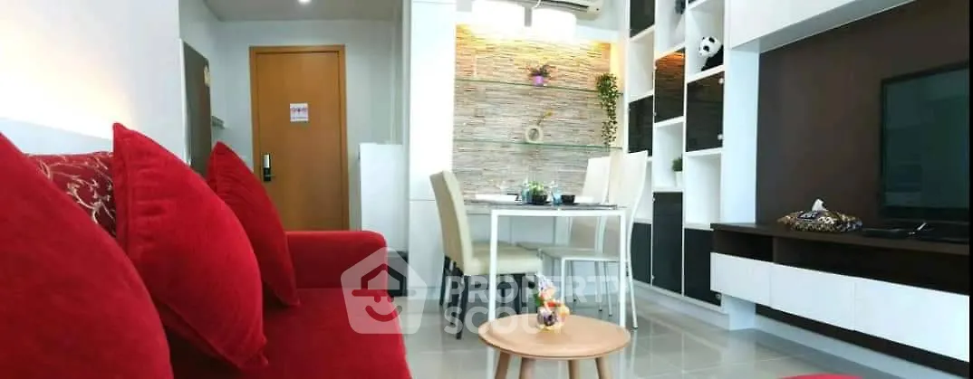 Modern living room with vibrant red sofa and stylish dining area in open layout apartment.