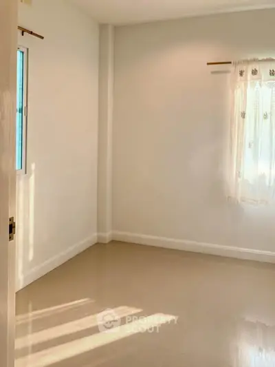 Bright empty room with tiled floor and sunlight streaming through windows, perfect for customization.