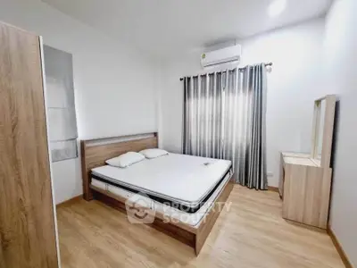 Modern bedroom with wooden flooring, stylish bed, and air conditioning unit.