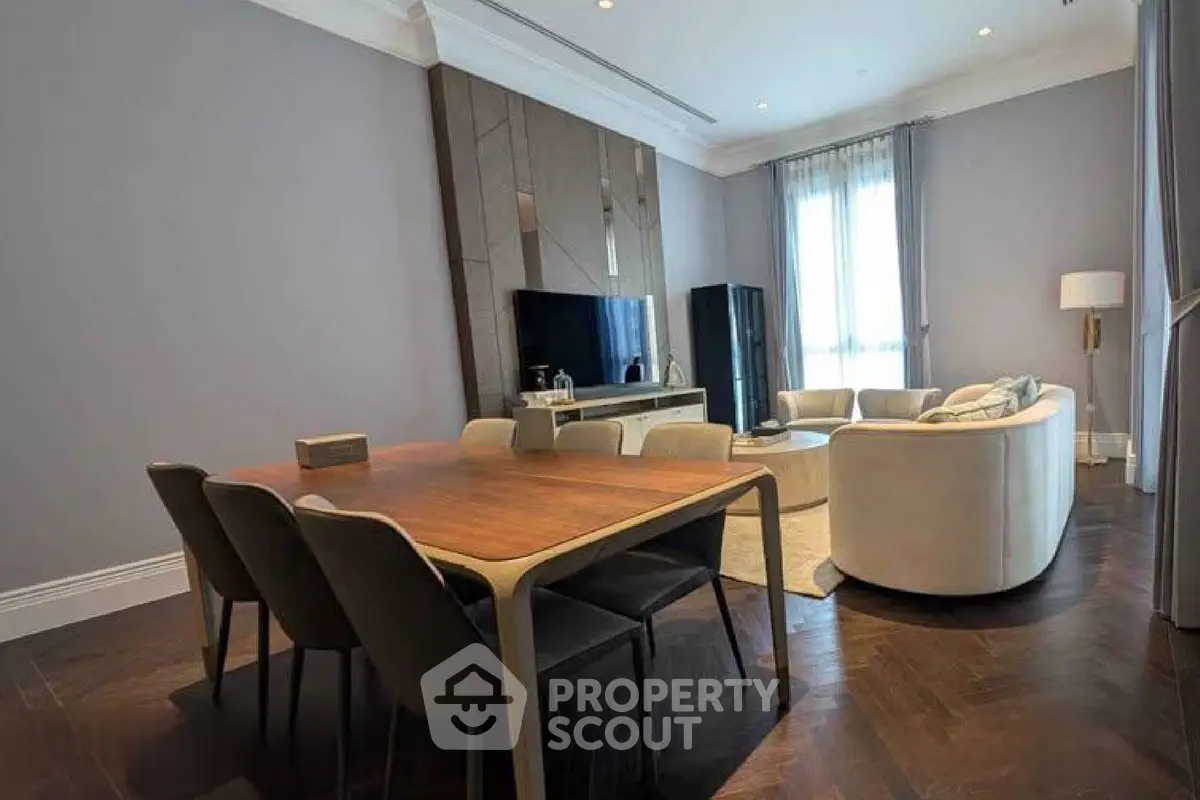 Elegant living room with modern dining area and cozy seating, featuring stylish decor and natural light.