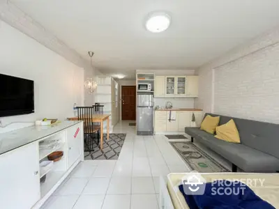 Modern open-plan living room with kitchen, featuring sleek furniture and bright decor.