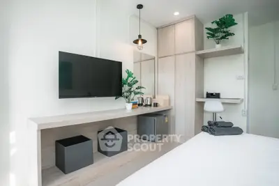 Modern bedroom with sleek TV setup and minimalist decor