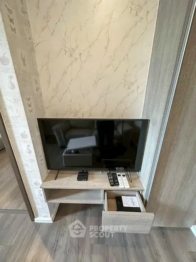 Modern living room with sleek TV setup and stylish wooden flooring.