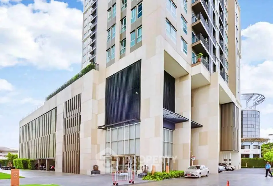 Modern high-rise building exterior with sleek design and urban surroundings.