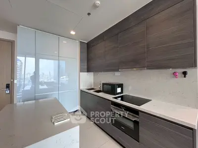 Modern kitchen with sleek cabinetry and built-in appliances in a high-rise apartment.
