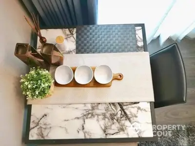 Stylish dining table with marble top and elegant decor in modern apartment.