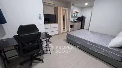 Modern studio apartment with sleek furniture and compact kitchen