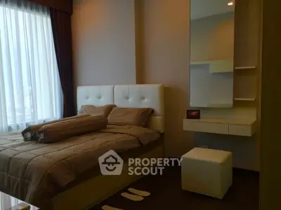 Luxurious bedroom with modern decor and large window offering natural light.