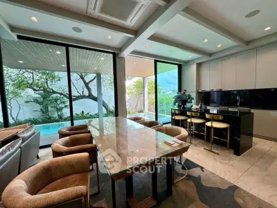 Luxurious open-plan living room with pool view and modern kitchen