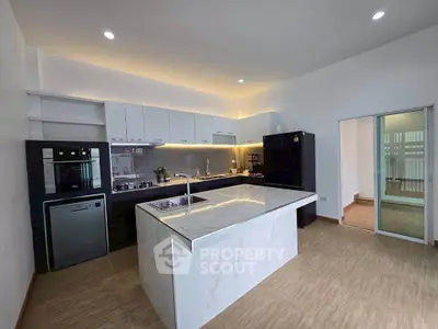 Modern kitchen with marble island and sleek appliances in open layout