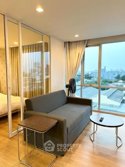Modern living room with city view, featuring a cozy sofa and elegant decor.