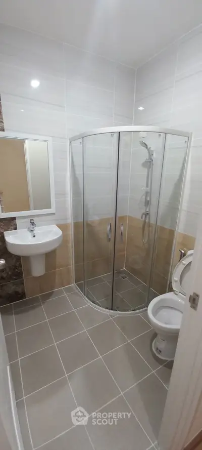 Modern bathroom with glass shower enclosure and sleek fixtures.