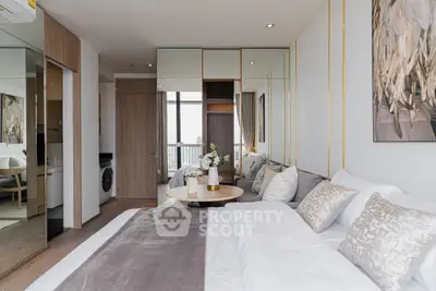 Modern bedroom with elegant decor and city view, featuring a cozy bed and stylish furnishings.