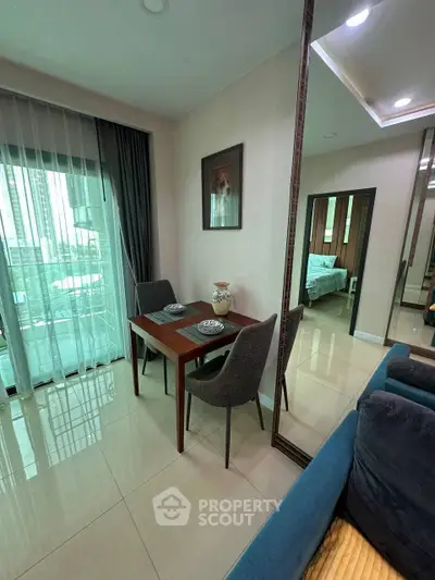 Modern apartment interior with dining area and view of bedroom, featuring elegant decor and natural light.