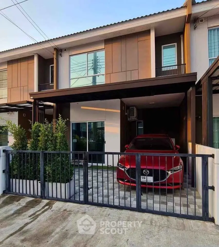 Modern townhouse with sleek design and carport in a serene neighborhood.