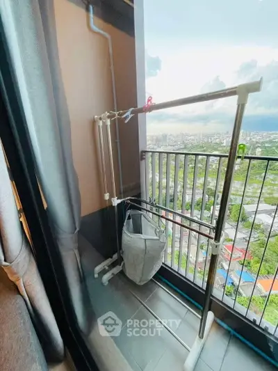 High-rise balcony with city view and drying rack, perfect for urban living.