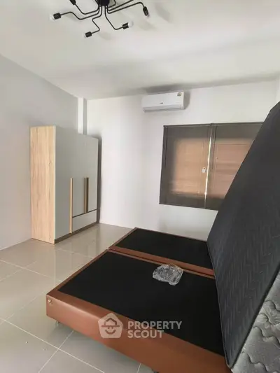 Spacious bedroom with modern wardrobe and air conditioning unit