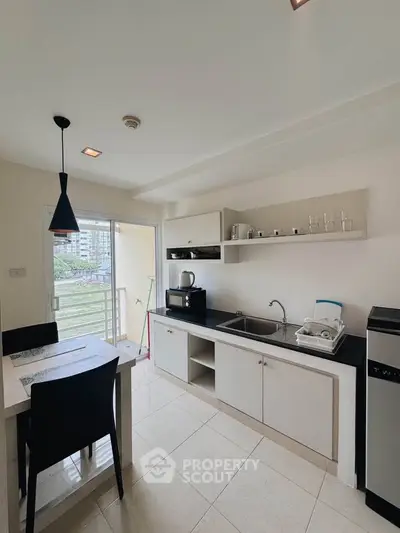Modern kitchen with sleek design, open layout, and balcony view in a stylish apartment.