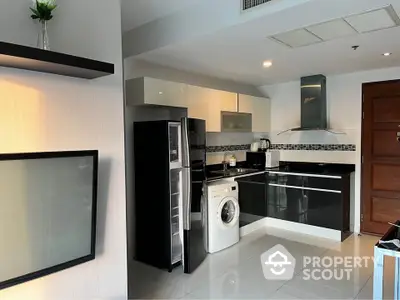 Modern kitchen with sleek black cabinets and built-in appliances, featuring a washing machine and stylish backsplash.