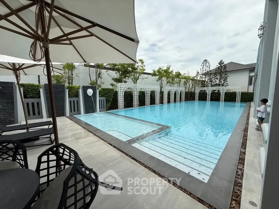 Luxurious outdoor pool area with modern design and elegant seating, perfect for relaxation and entertainment.