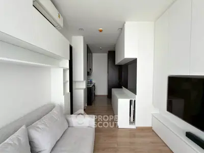 Modern living room with sleek white cabinetry and cozy gray sofa